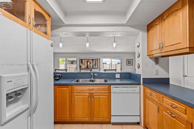 a kitchen with granite countertop a sink and a refrigerator