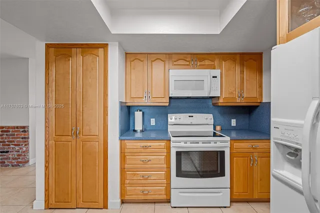a kitchen with stainless steel appliances granite countertop white cabinets and a stove top oven