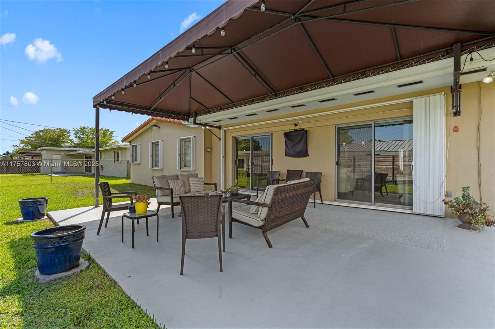 6311 Southwest 93rd Court Miami, FL 33173 - Photo 34 of 41 a patio with couches table and chairs under an umbrella