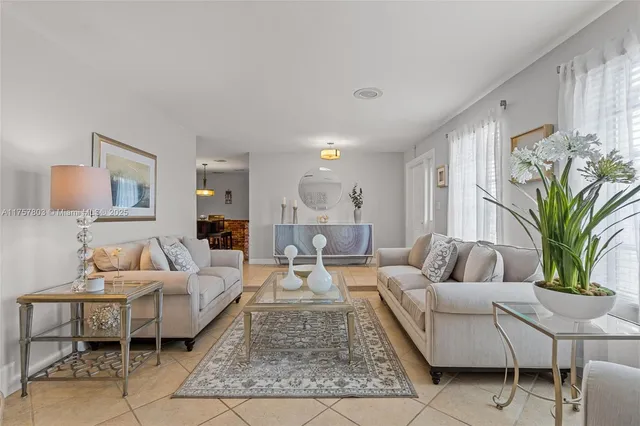 a living room with furniture potted plant and a window