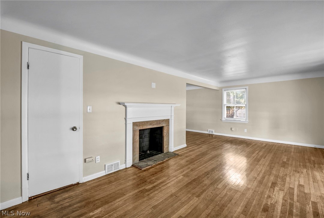 2313 North Taylor Road Cleveland Heights, OH 44112 - Photo 5 of 32 Spacious living area featuring wood-finish flooring, a traditional fireplace with a white mantel, and neutral wall tones