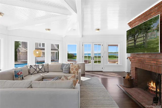 a living room with furniture large window and fireplace