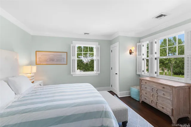 a bedroom with a bed a window and dresser