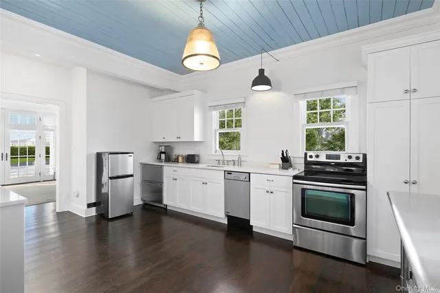 a kitchen with stainless steel appliances a stove a sink and a refrigerator