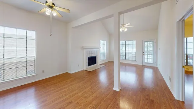 wooden floor fireplace and windows in an empty room