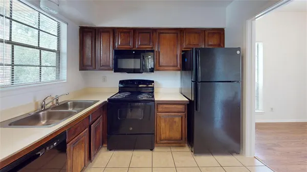 a kitchen with a refrigerator sink and cabinets