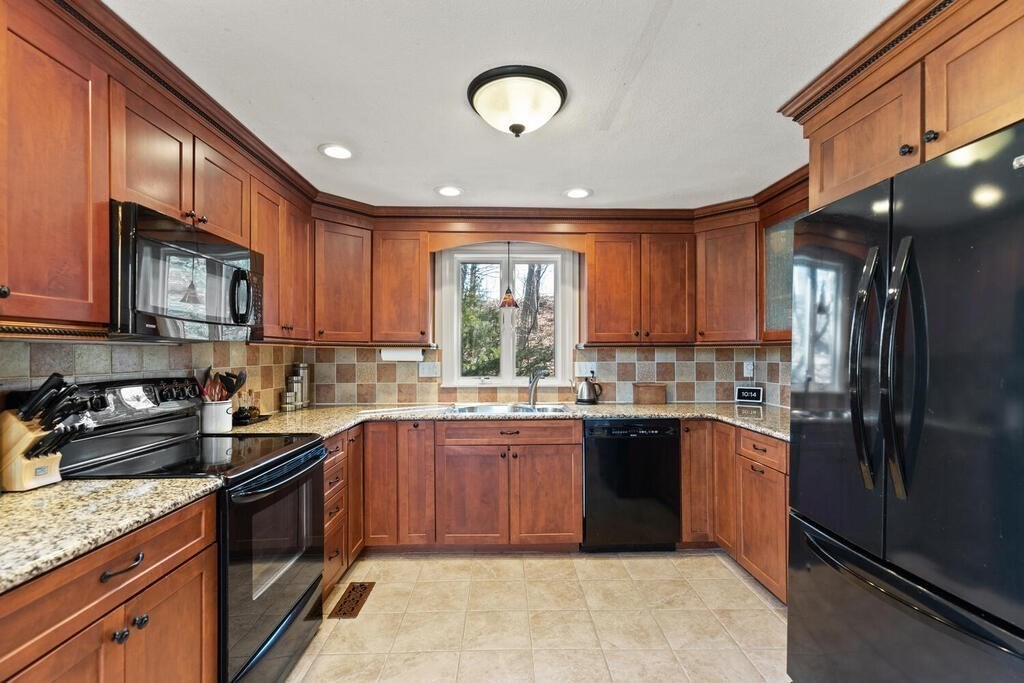 73 Longfellow Road Reading, MA 01867 - Photo 14 of 32 a kitchen with stainless steel appliances granite countertop a sink a stove cabinets and a refrigerator