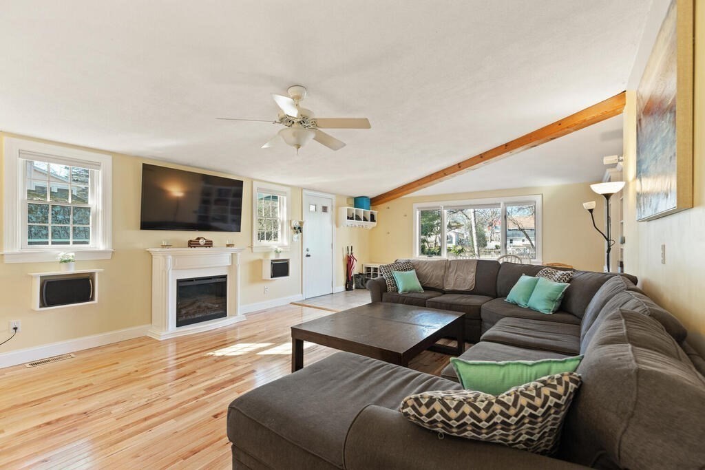 73 Longfellow Road Reading, MA 01867 - Photo 6 of 32 a living room with furniture a flat screen tv and a fireplace