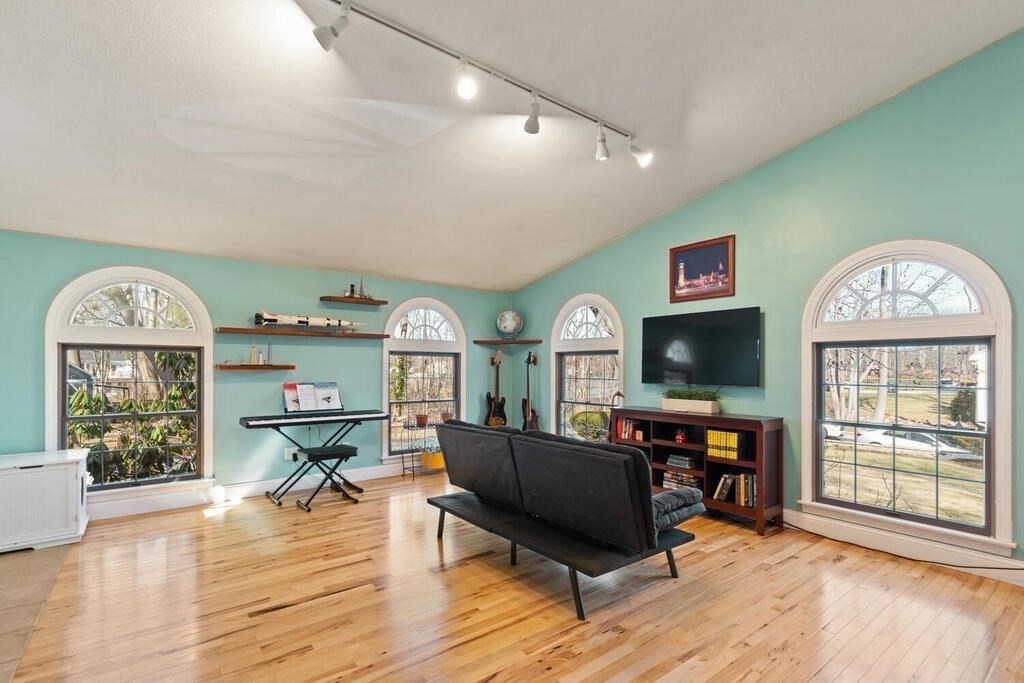 73 Longfellow Road Reading, MA 01867 - Photo 8 of 32 a living room with furniture a fireplace and a flat screen tv
