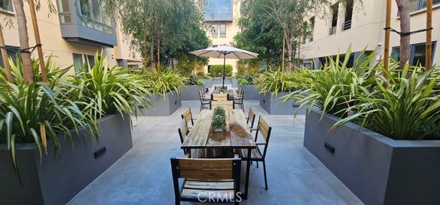 a view of a patio with table and chairs potted plants with wooden floor