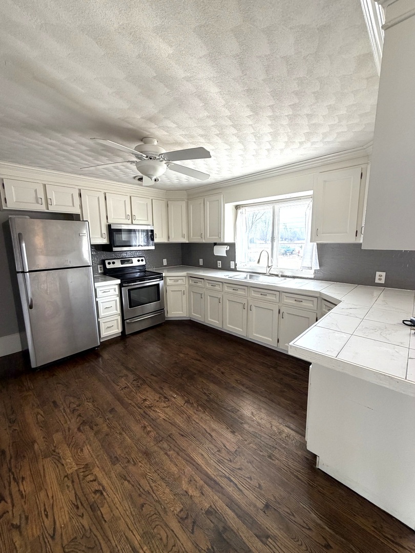 401 North Street Mazon, IL 60444 - Photo 9 of 23 a kitchen with a sink wooden floor and stainless steel appliances