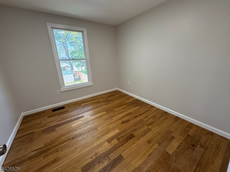 87 Fairview Avenue Somerville, NJ 08876 - Photo 17 of 19 an empty room with wooden floor and window