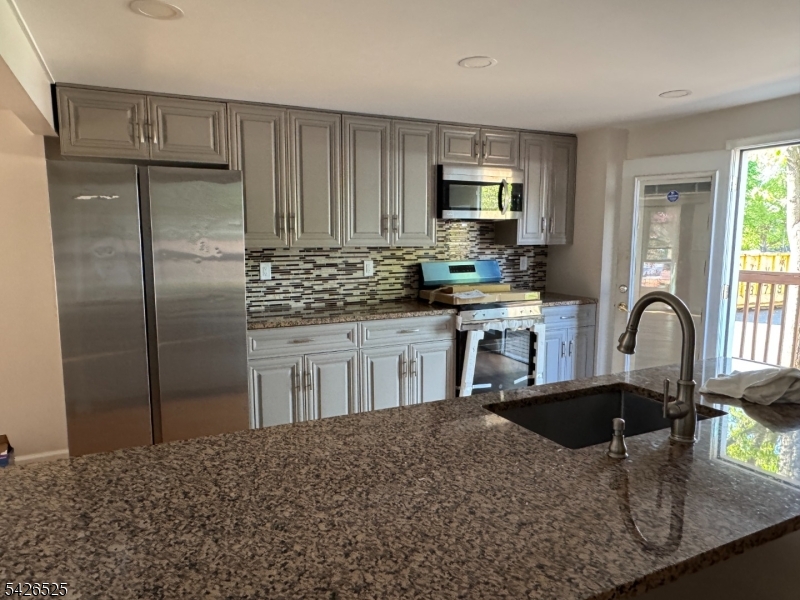 87 Fairview Avenue Somerville, NJ 08876 - Photo 3 of 19 a kitchen with stainless steel appliances granite countertop a sink a stove a refrigerator cabinets and living room