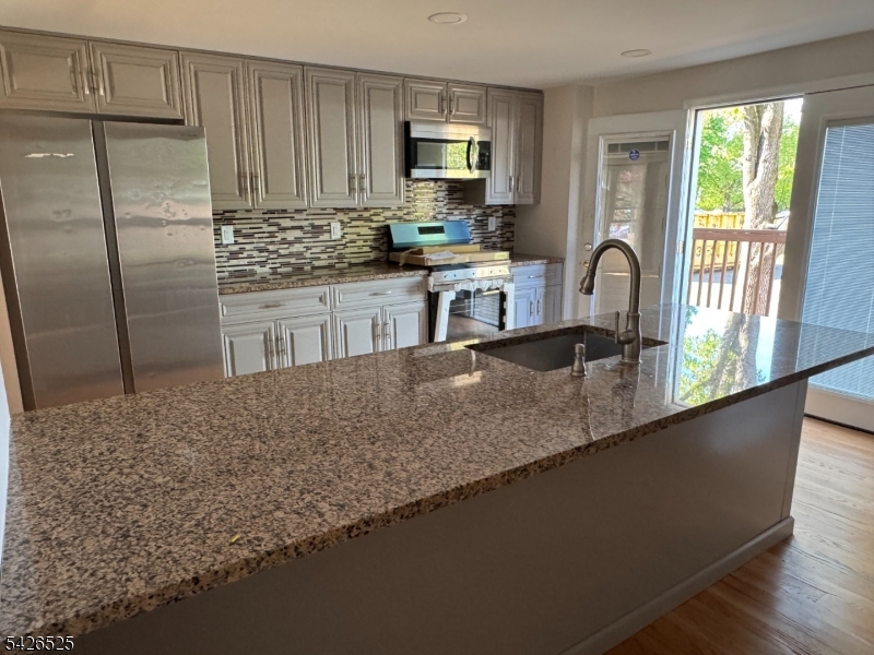 87 Fairview Avenue Somerville, NJ 08876 - Photo 4 of 19 a kitchen with granite countertop a sink a counter top space and stainless steel appliances