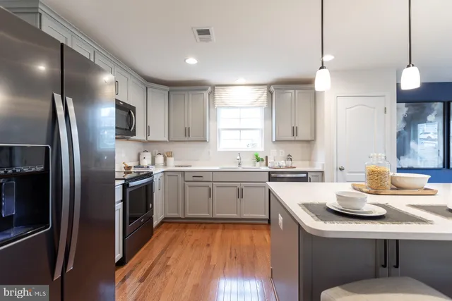 a kitchen with a sink stainless steel appliances and window