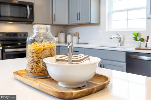 a view of a kitchen with granite countertop a sink a stove and a microwave