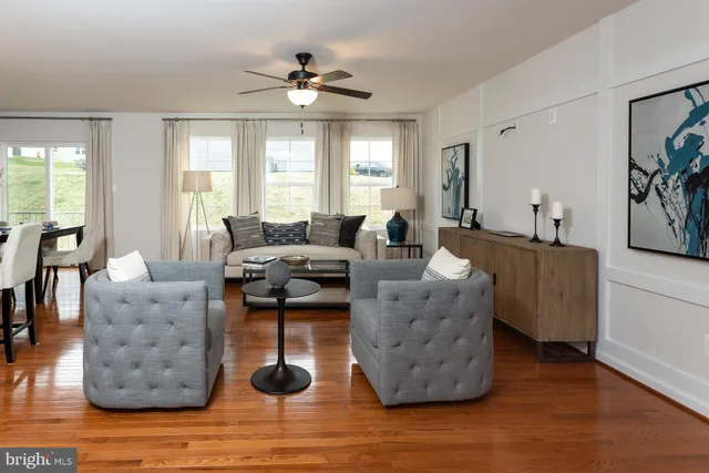 a living room with couches and a large mirror with wooden floor