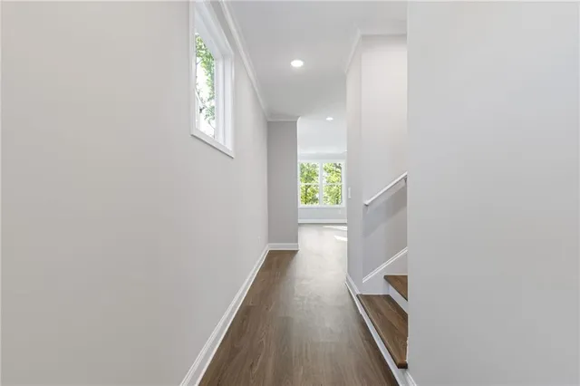a view of a hallway with wooden floor and staircase