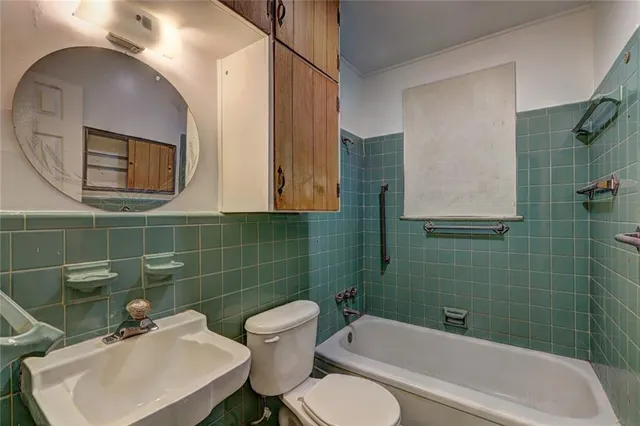 a bathroom with a sink mirror toilet and bathtub