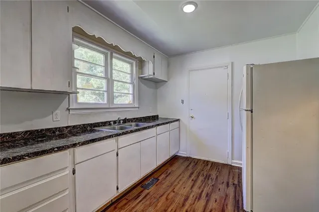 a kitchen with wooden floors and a sink