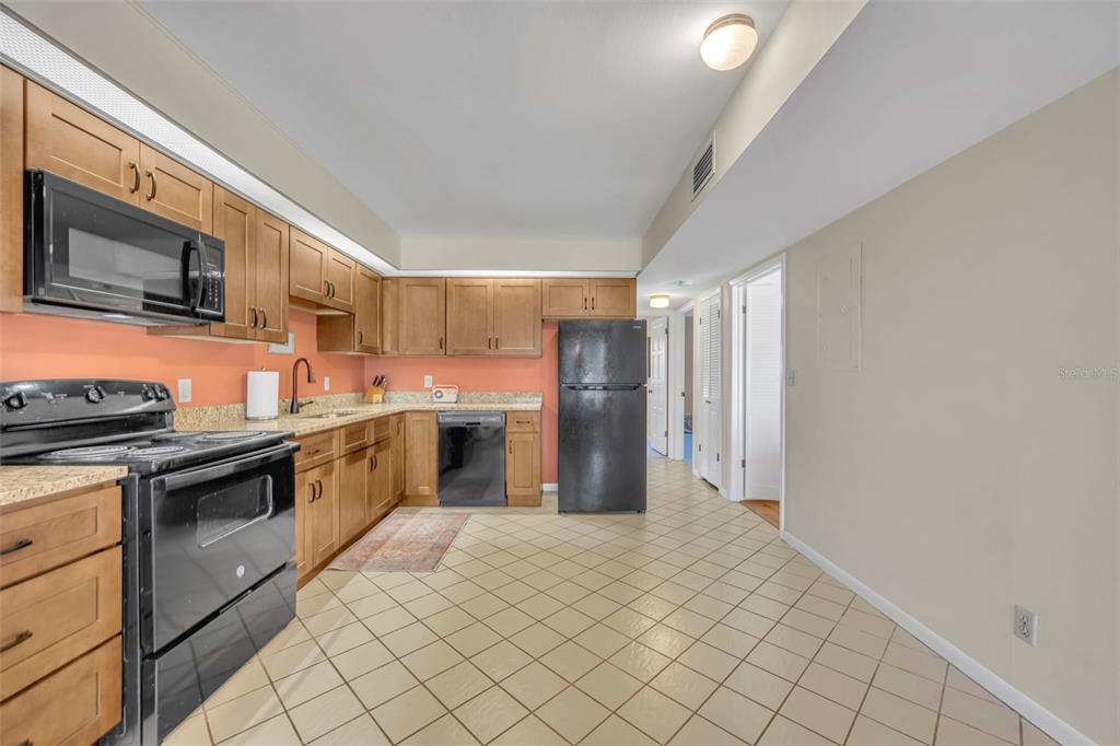 1902 Abbington Street, Unit 1902 Apopka, FL 32712 - Photo 12 of 32 a kitchen with stainless steel appliances granite countertop a refrigerator and a stove top oven