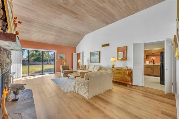 a living room with furniture large window and wooden floor