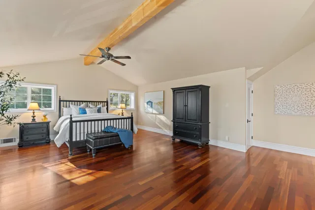 a bedroom with a bed and wooden floor