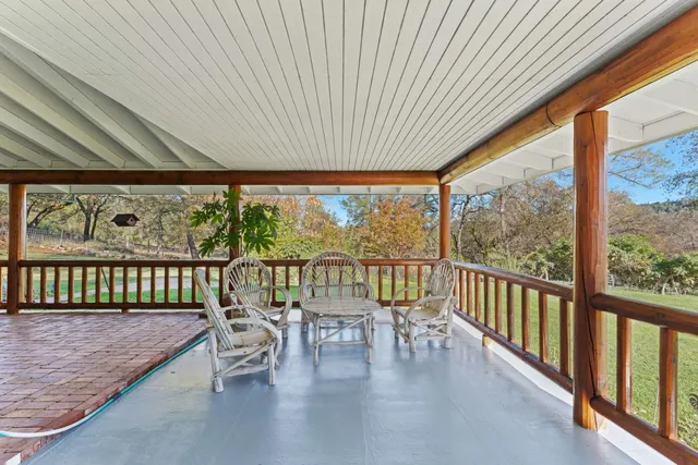 a view of a house with a yard deck and a large tree