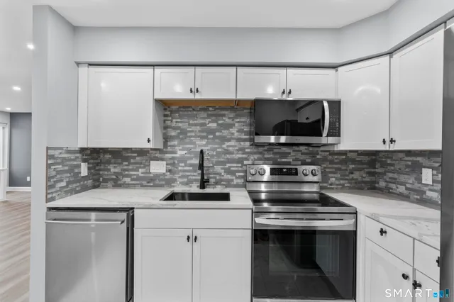 a kitchen with stainless steel appliances a sink stove and microwave