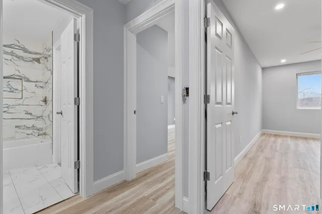 a view of a hallway with wooden floor and front door