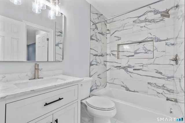 a bathroom with a sink toilet vanity and shower