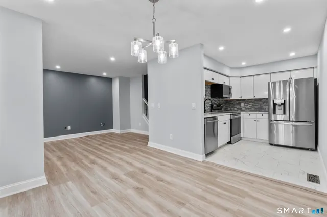 a view of a kitchen with a sink and stainless steel appliances