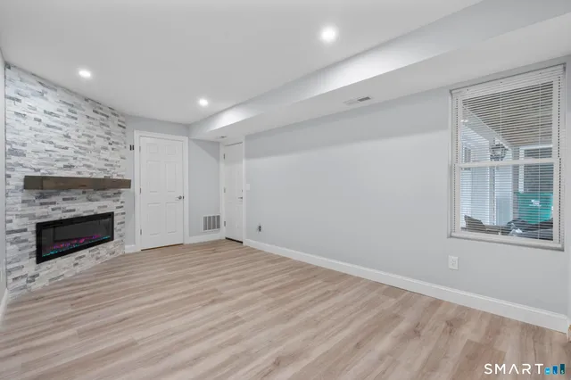 a view of empty room with wooden floor and fireplace