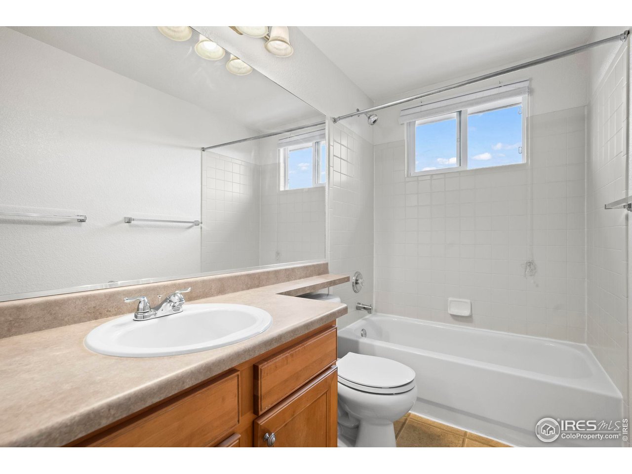 2529 Azalea Way Erie, CO 80516 - Photo 19 of 32 a bathroom with a granite countertop sink toilet a mirror and shower