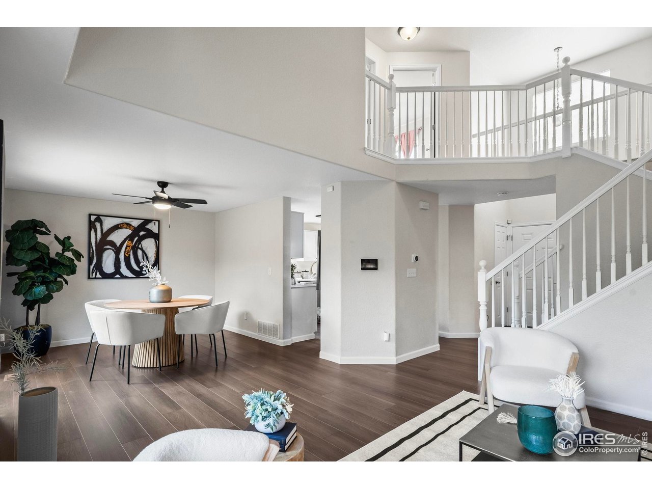 2529 Azalea Way Erie, CO 80516 - Photo 32 of 32 a living room with couches and a dining table with wooden floor