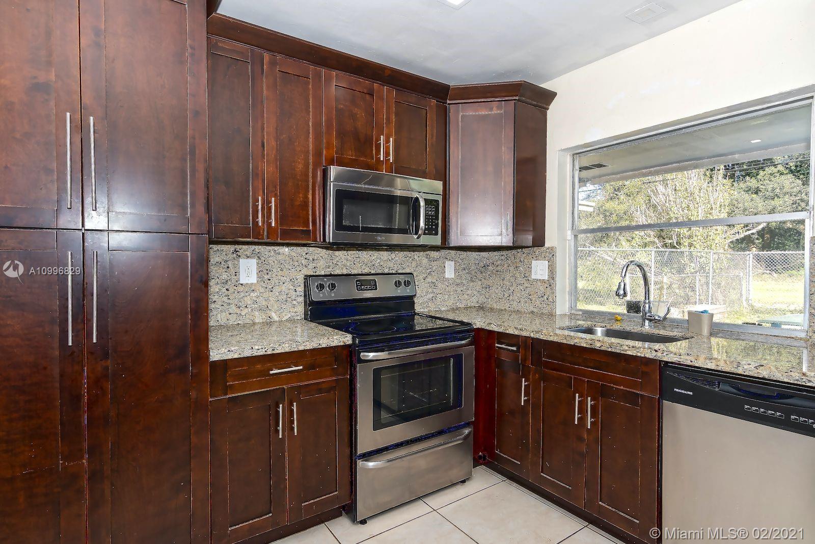 3829 East Shore Road Miramar, FL 33023 - Photo 5 of 14 a kitchen with a sink stove and microwave