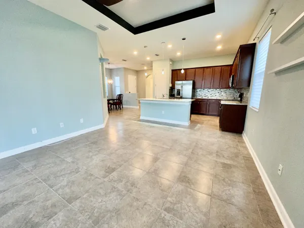 a view of kitchen with stainless steel appliances kitchen island granite countertop a stove a sink a refrigerator and white cabinets