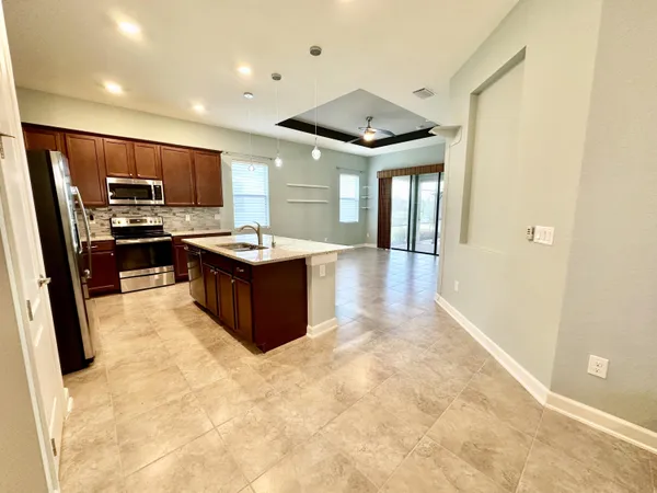 a kitchen with kitchen island a sink stainless steel appliances and cabinets
