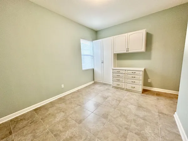 a view of an empty room with cabinet and a window