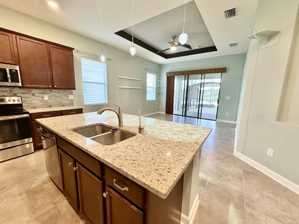 a kitchen with stainless steel appliances granite countertop a sink window and cabinets