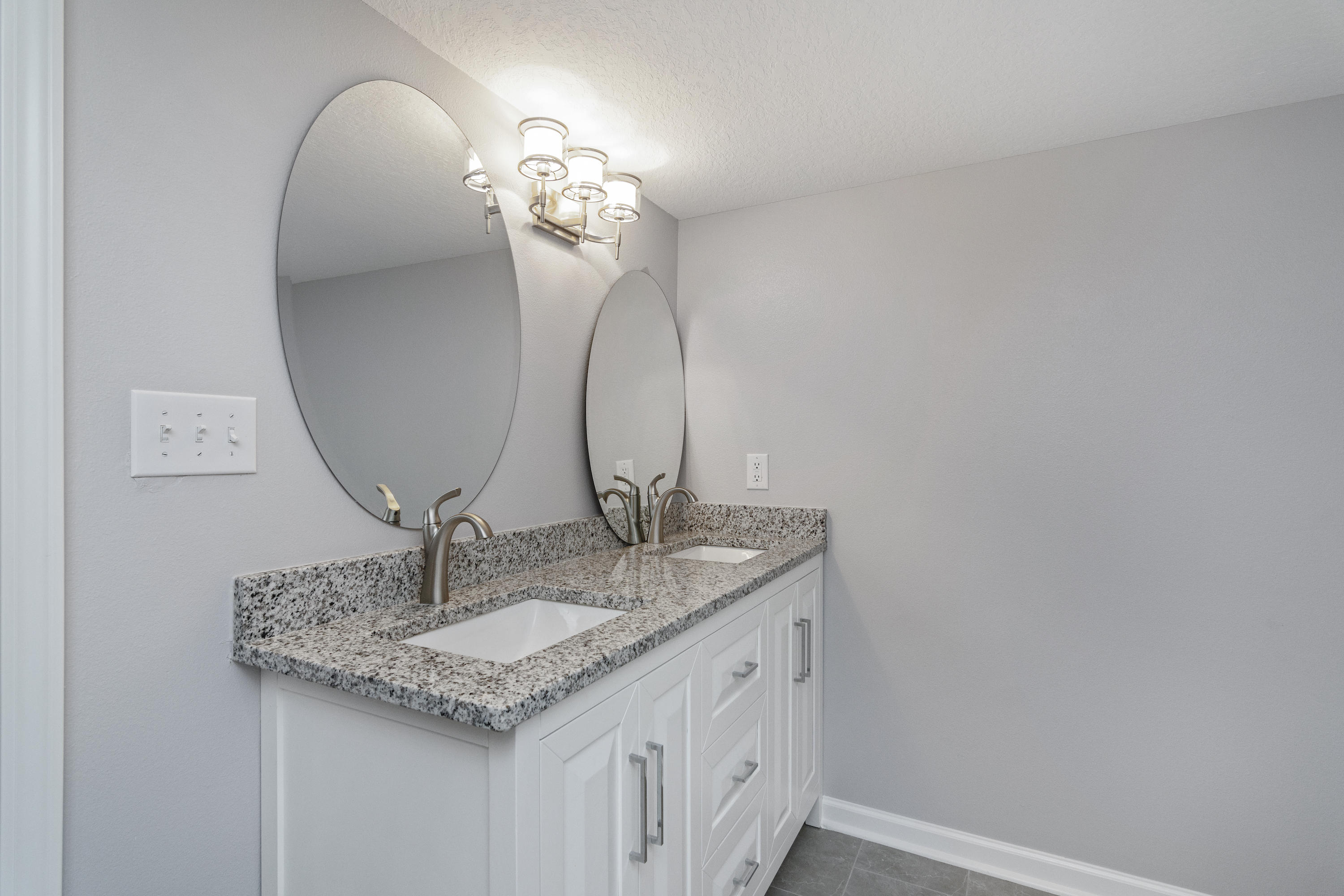 3032 Adams Road Crestview, FL 32536 - Photo 18 of 41 a bathroom with a granite countertop sink a mirror and vanity