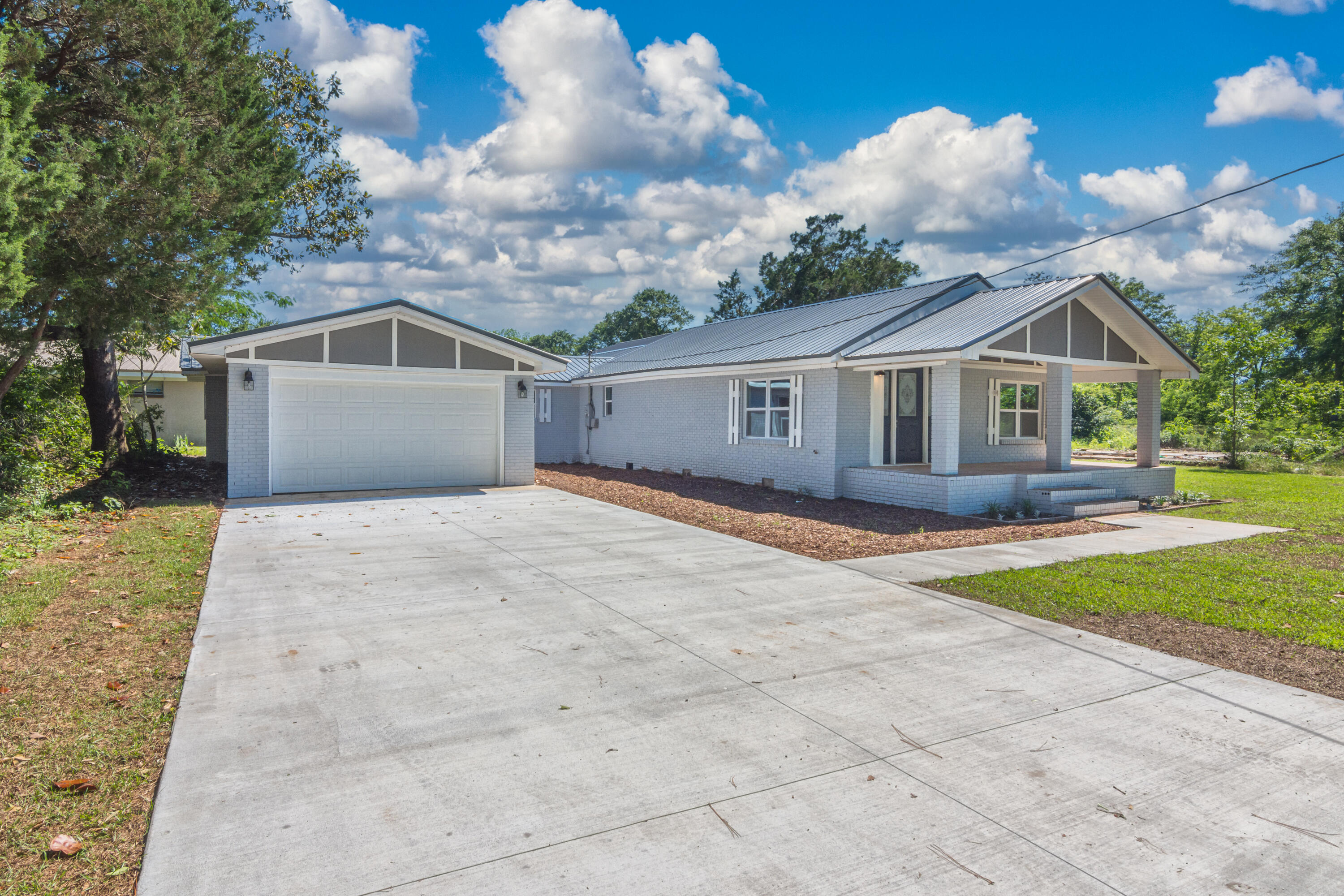 3032 Adams Road Crestview, FL 32536 - Photo 2 of 41 a front view of a house with a yard and garage