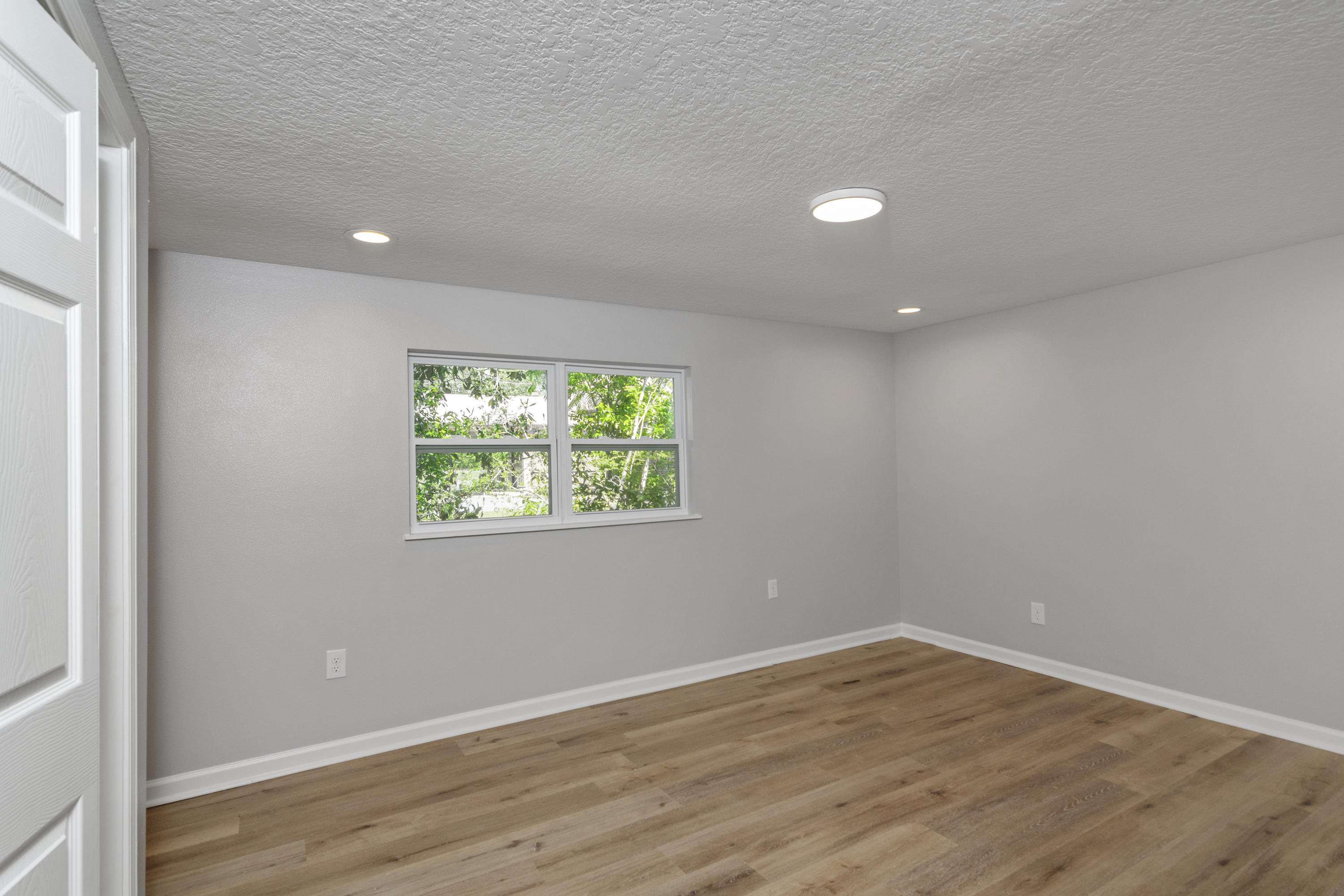 3032 Adams Road Crestview, FL 32536 - Photo 27 of 41 an empty room with wooden floor and windows