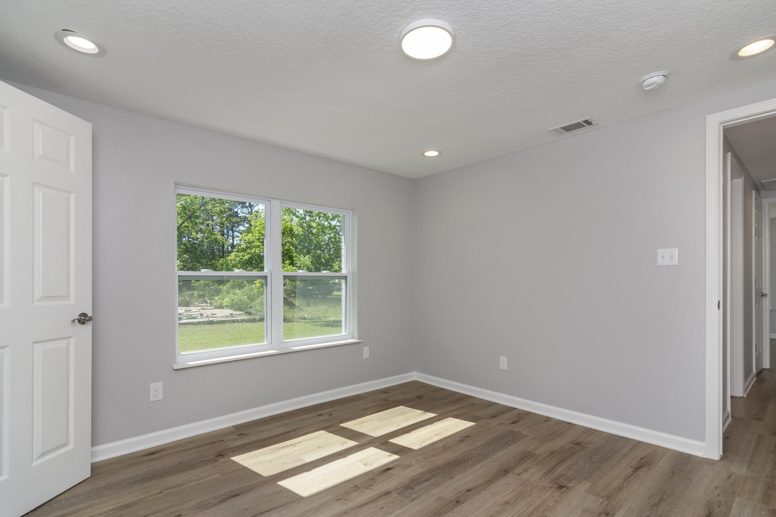 3032 Adams Road Crestview, FL 32536 - Photo 37 of 41 an empty room with wooden floor and windows