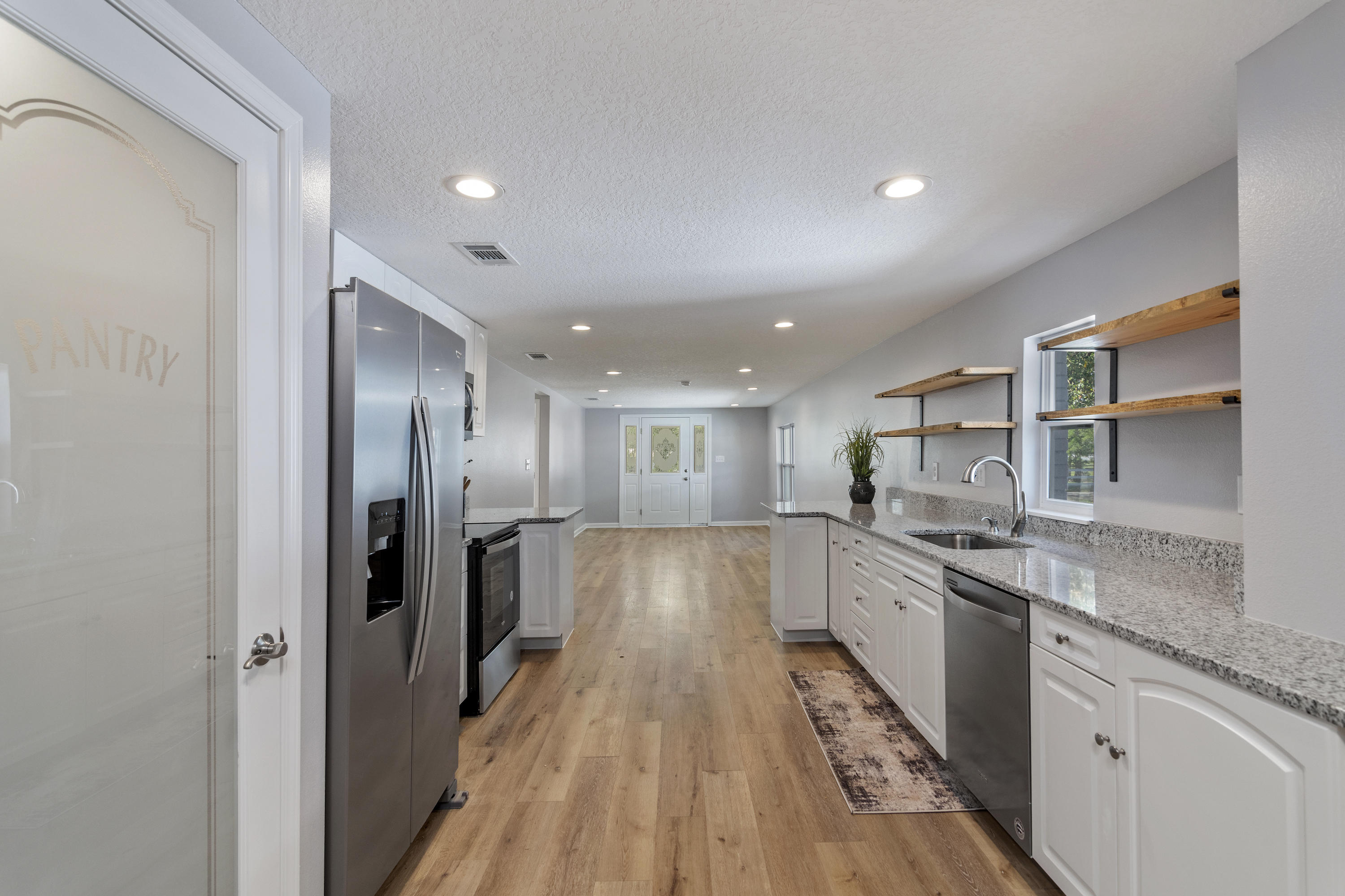 3032 Adams Road Crestview, FL 32536 - Photo 6 of 41 a view of a kitchen with a sink and wooden floor