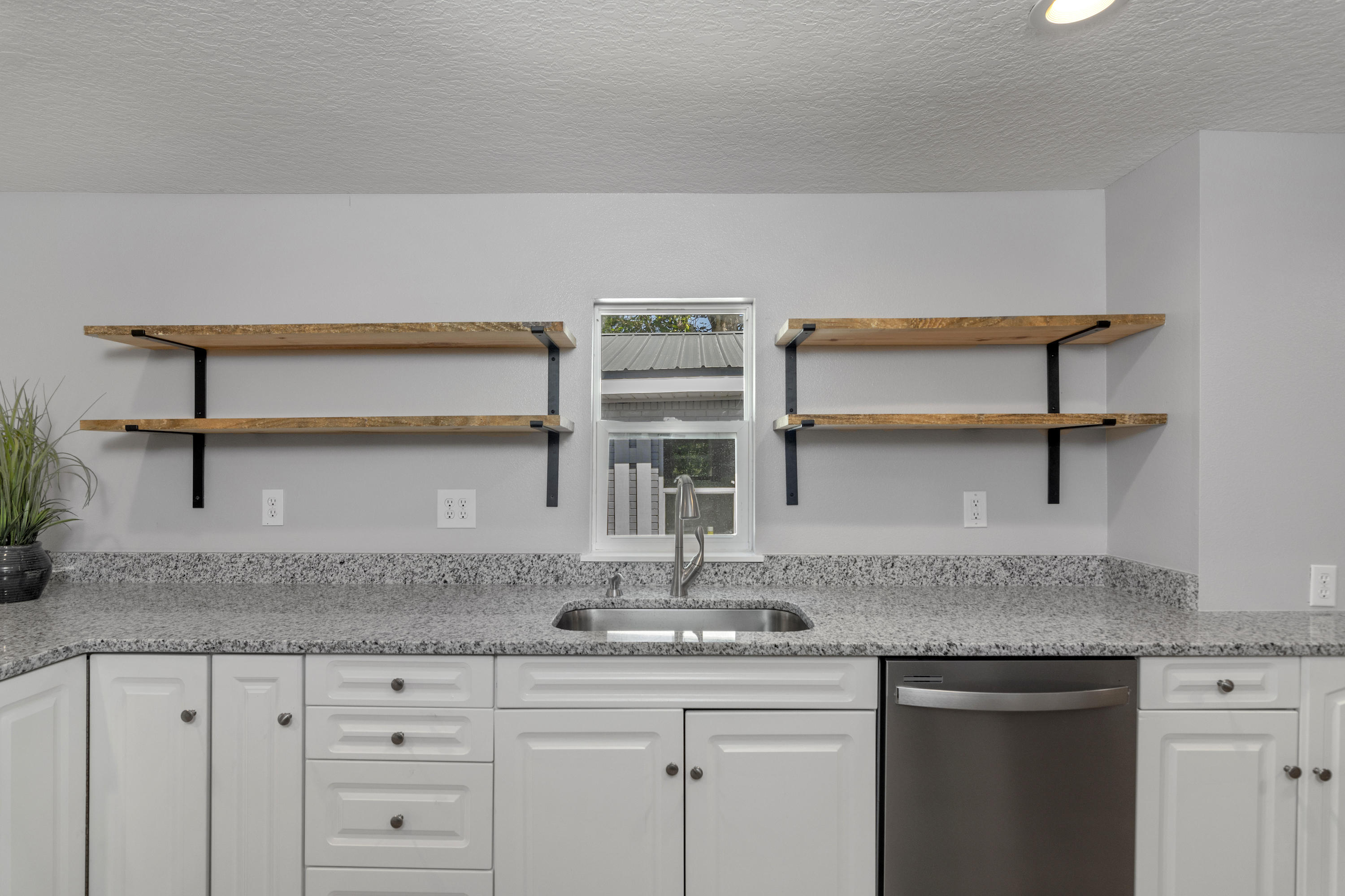 3032 Adams Road Crestview, FL 32536 - Photo 7 of 41 a kitchen with granite countertop a sink and cabinets