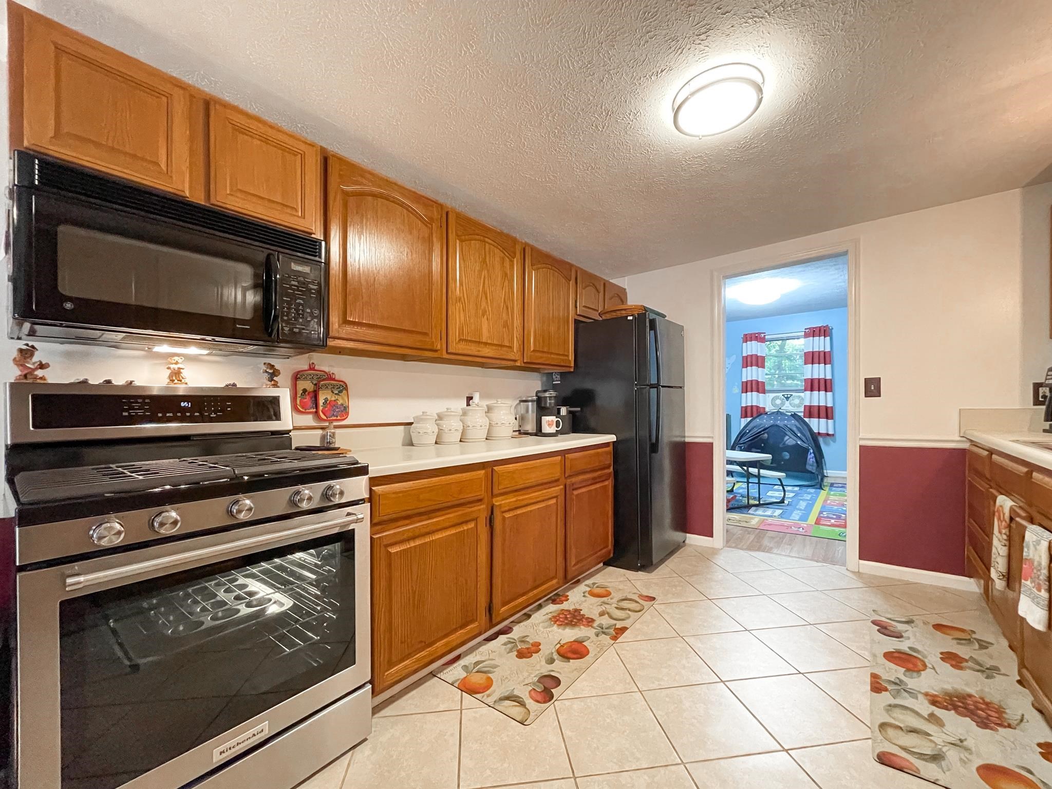 172 Beagle Gap Run Waynesboro, VA 22980 - Photo 15 of 32 a kitchen with stainless steel appliances kitchen island granite countertop a stove microwave and cabinets