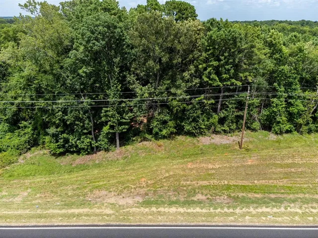 an aerial view of residential house with outdoor space and trees all around