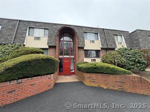 a front view of a house with a yard and potted plants