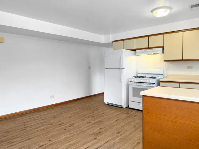 a kitchen with a refrigerator and a stove top oven